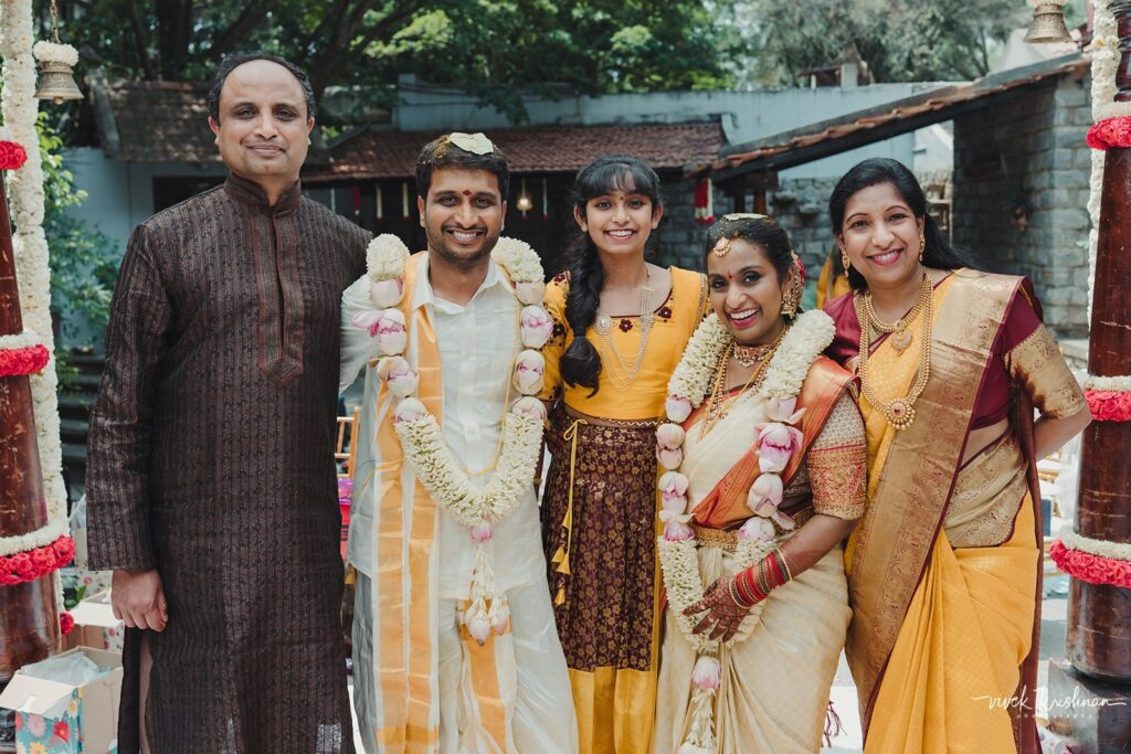 The tales of tradition wedding planners- couple with family in their wedding